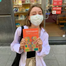 Wearing a mask and holding a book 